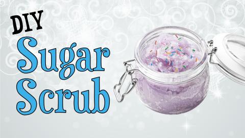 Image reads "DIY Sugar Scrub" against a white background. A jar of sugar scrub with sprinkles in it is to the right of the title.