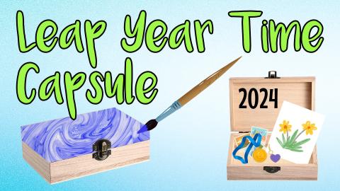 Image reads "Leap Year Time Capsule" against a gradient blue background. Two wooden boxes are under the title, the left box is closed and the right box is opened with mementos inside the box.