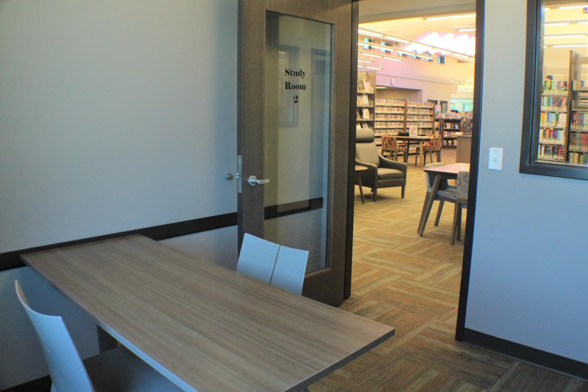 A table attached to the wall with two chairs.